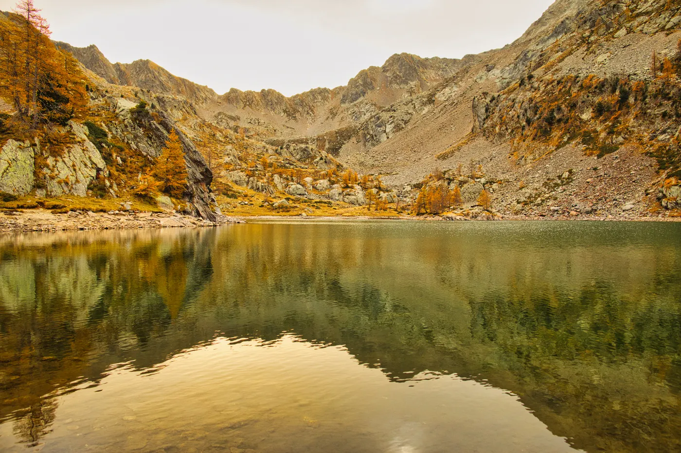 Un lac tranquille en automne entouré de montagnes à Saint-Martin-Vésubie, France.